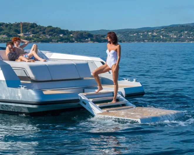 Santasevera 42 at speed with bow wave, Mediterranean coast in background